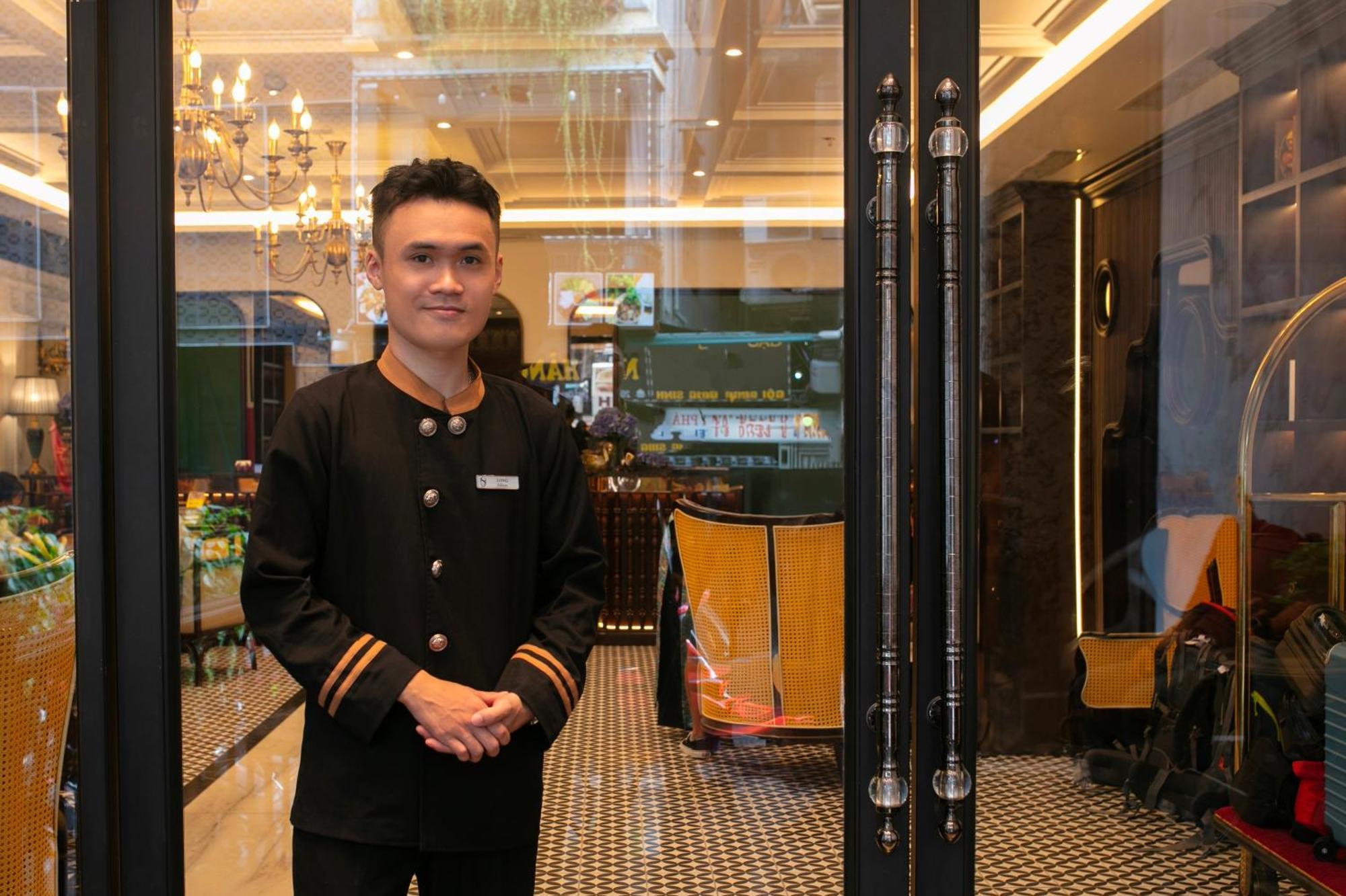 May De Ville Crown Hotel Hanói Exterior foto A doorman at the entrance of a hotel in Kuala Lumpur, Malaysia